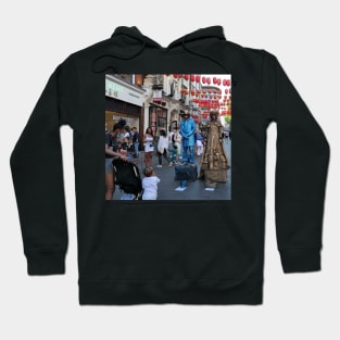 Little kid admiring the street performers in London. Hoodie